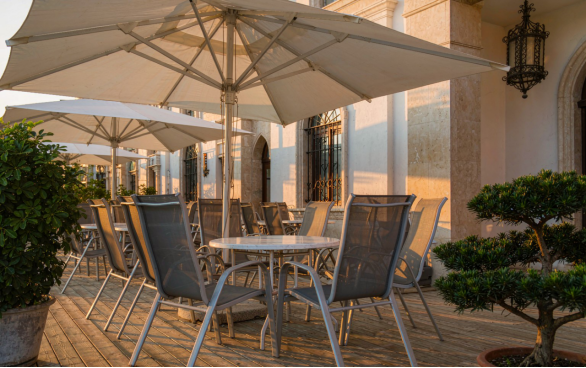 Terrasse restaurant : tables c&eacute;ramique, chaises empilables et parasols
